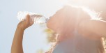 Fit blonde drinking from her water bottle on a sunny day