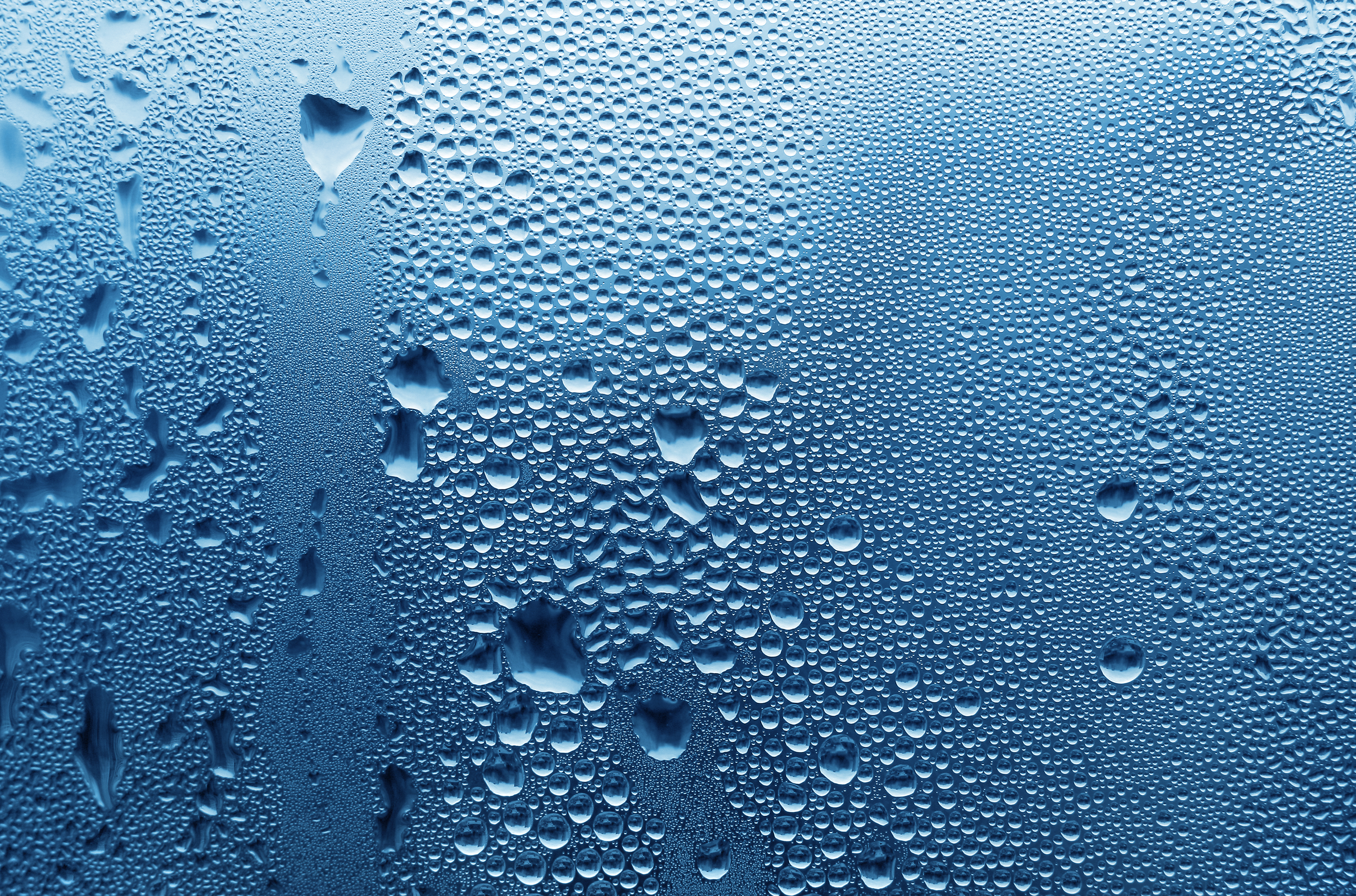 large and fine water drops on glass