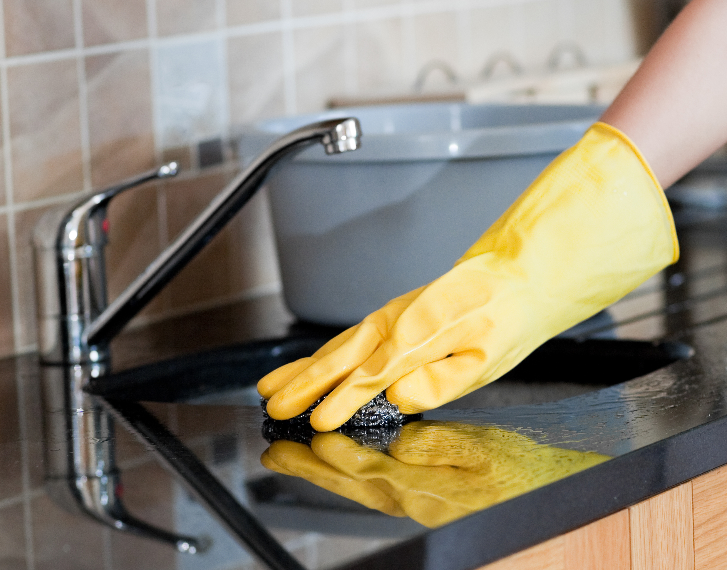 Close-up of a woman cleaning a kitchen at home