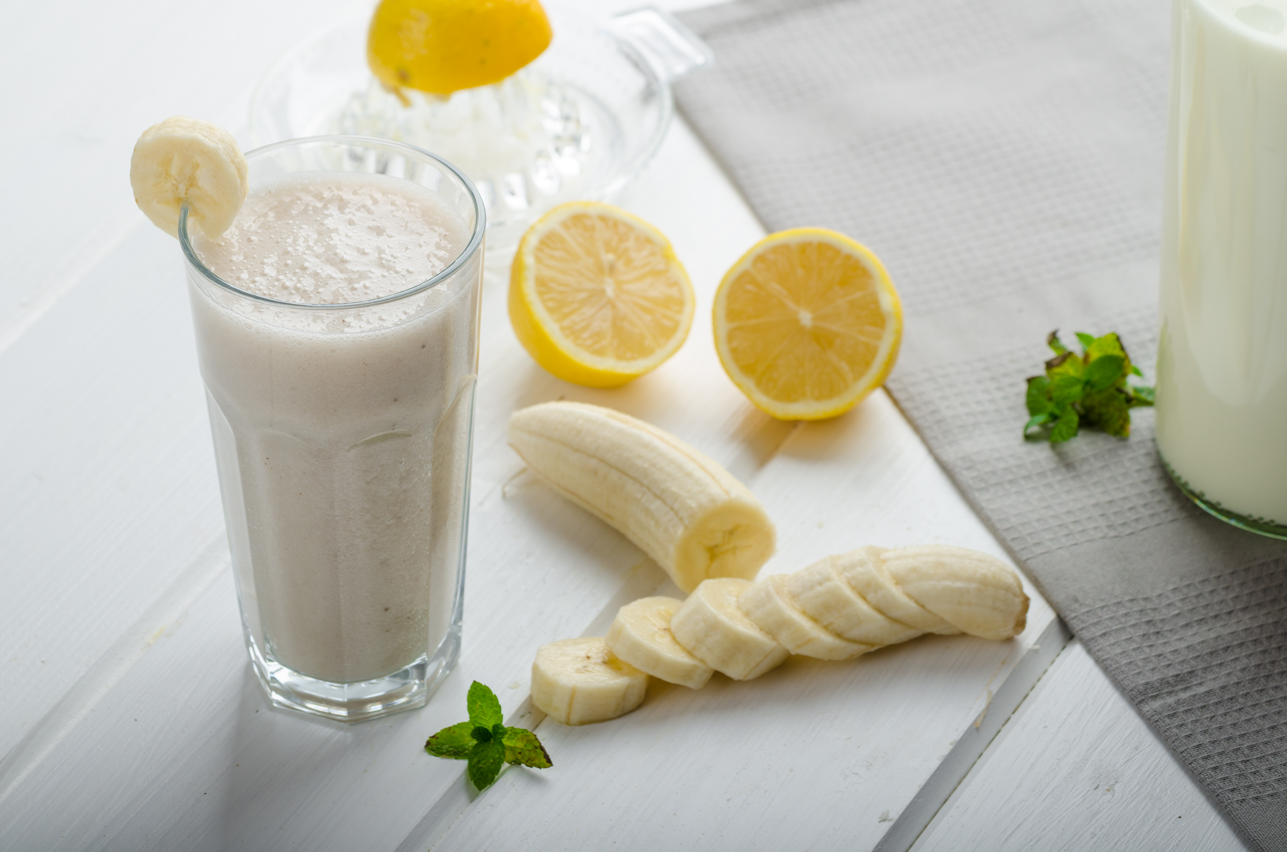 Homemade banana smoothie with lemons, herbs and organic milk from the farm