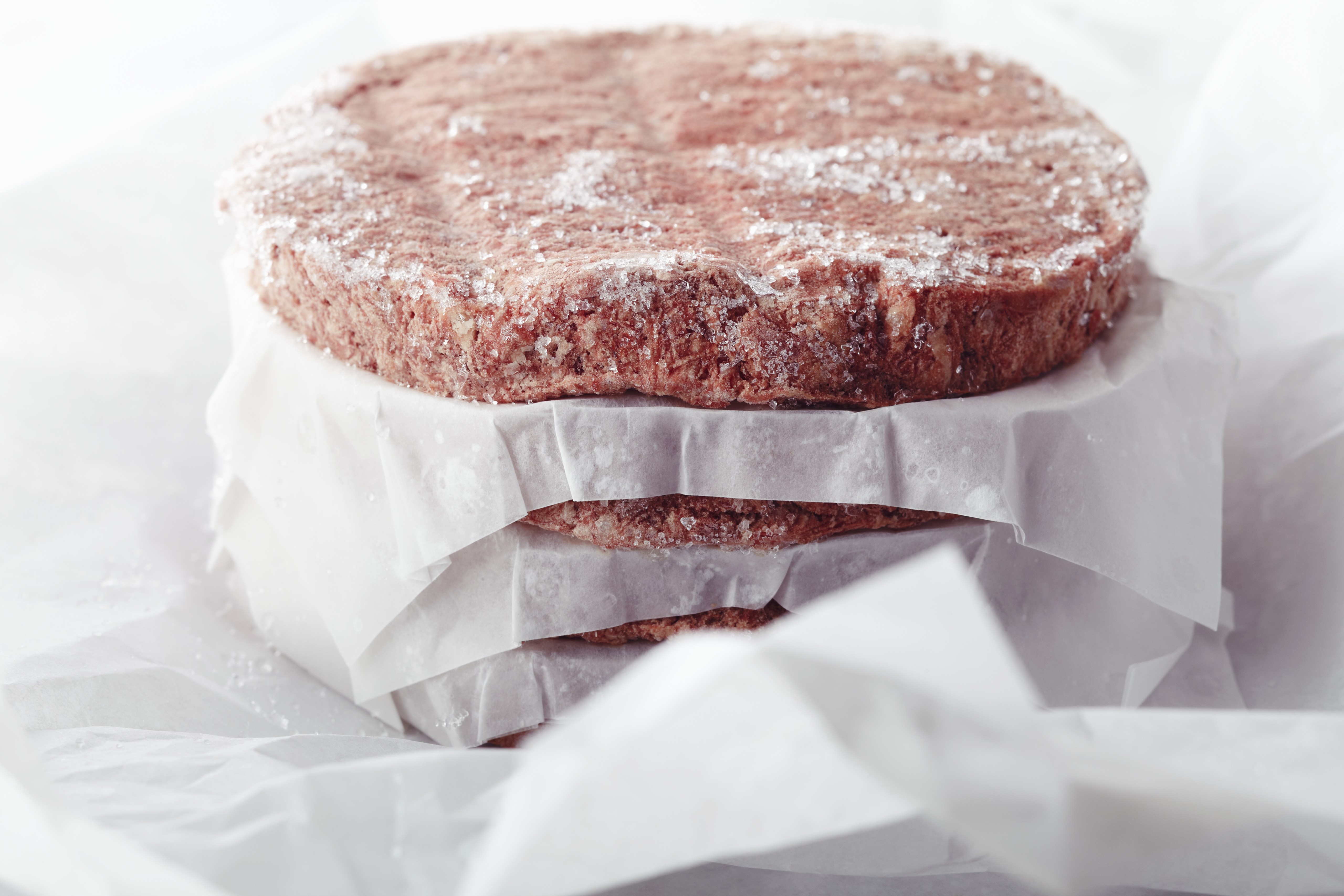 Stacked Frozen Hamburger Patties Divided with Paper