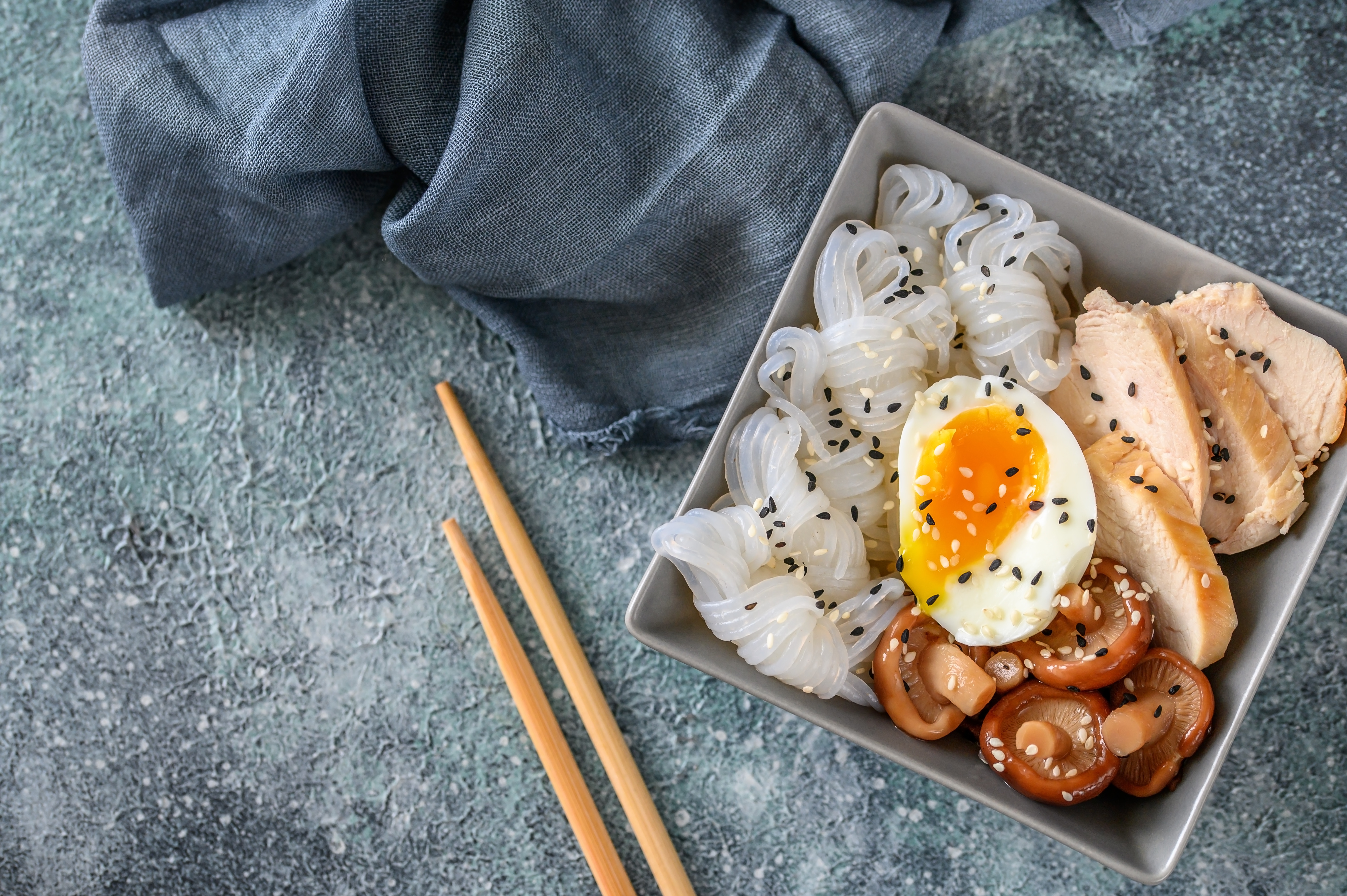 Bowl of Asian food with konnyaku, slices of chicken breast, shiitake and soft-boiled egg
