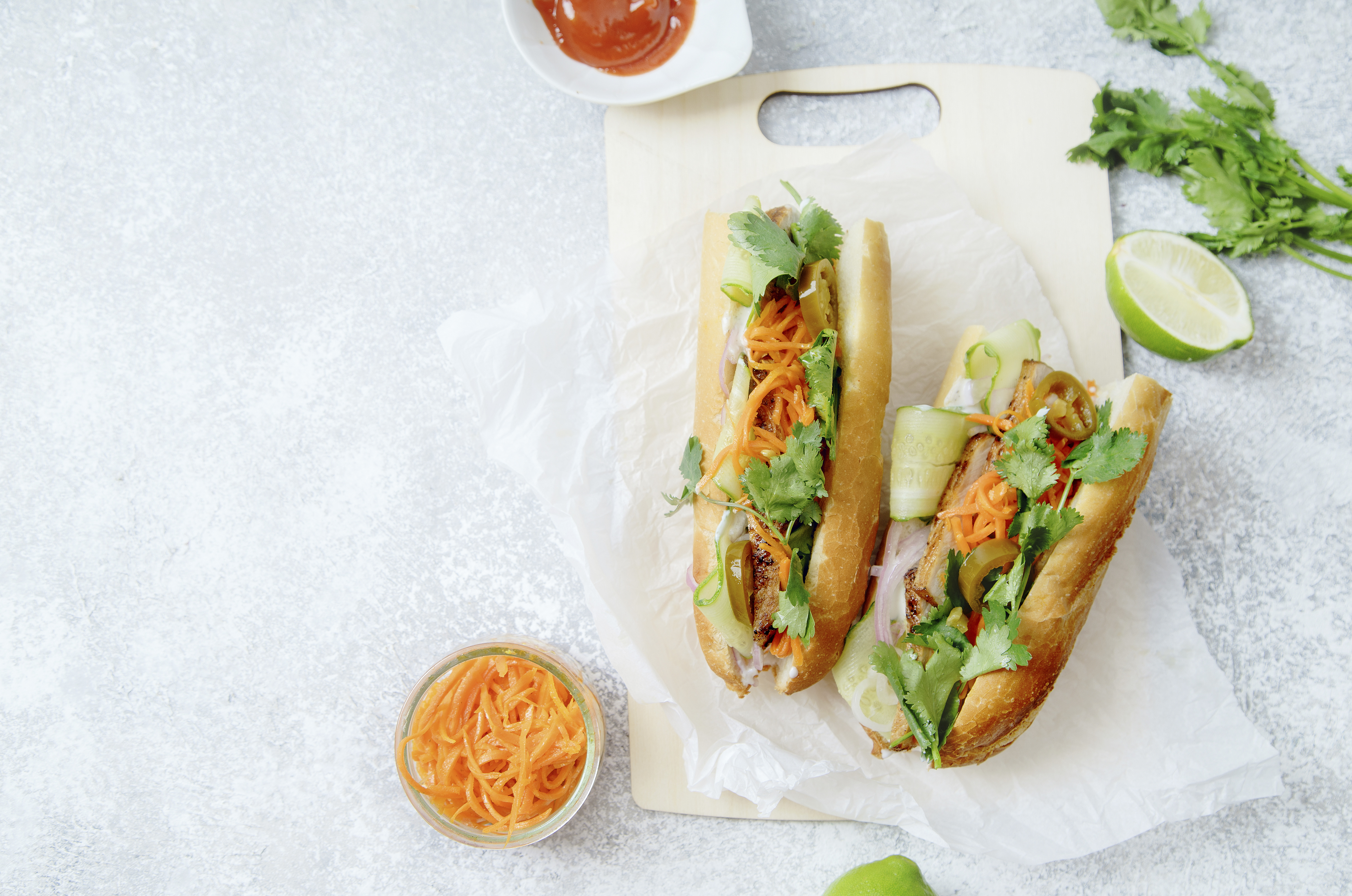 Classical banh-mi sandwich with sliced grilled pork tenderloin, carrots, cucumbers, jalapeno peppers and cilantro