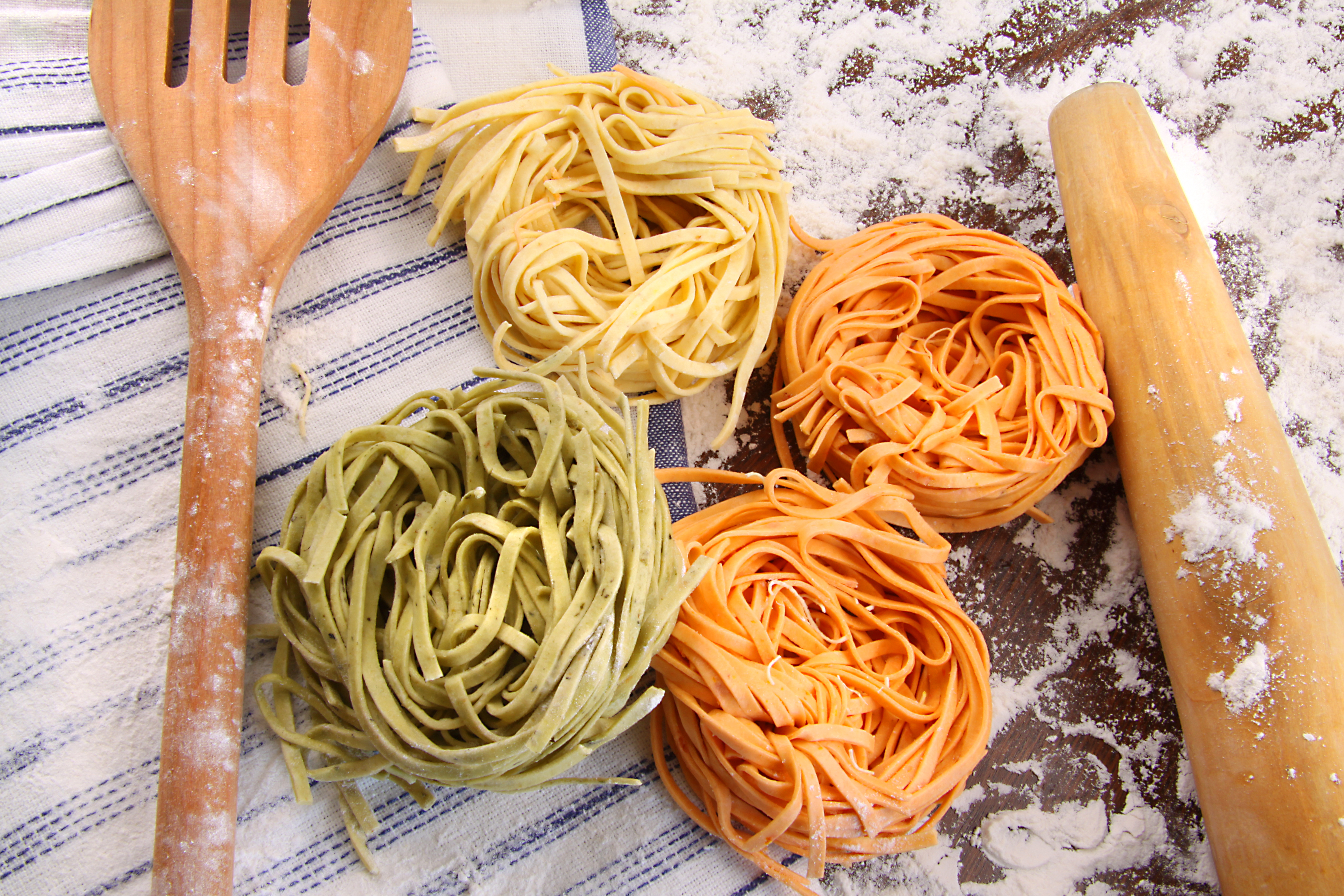 Assortment of different colored italian pasta on flour