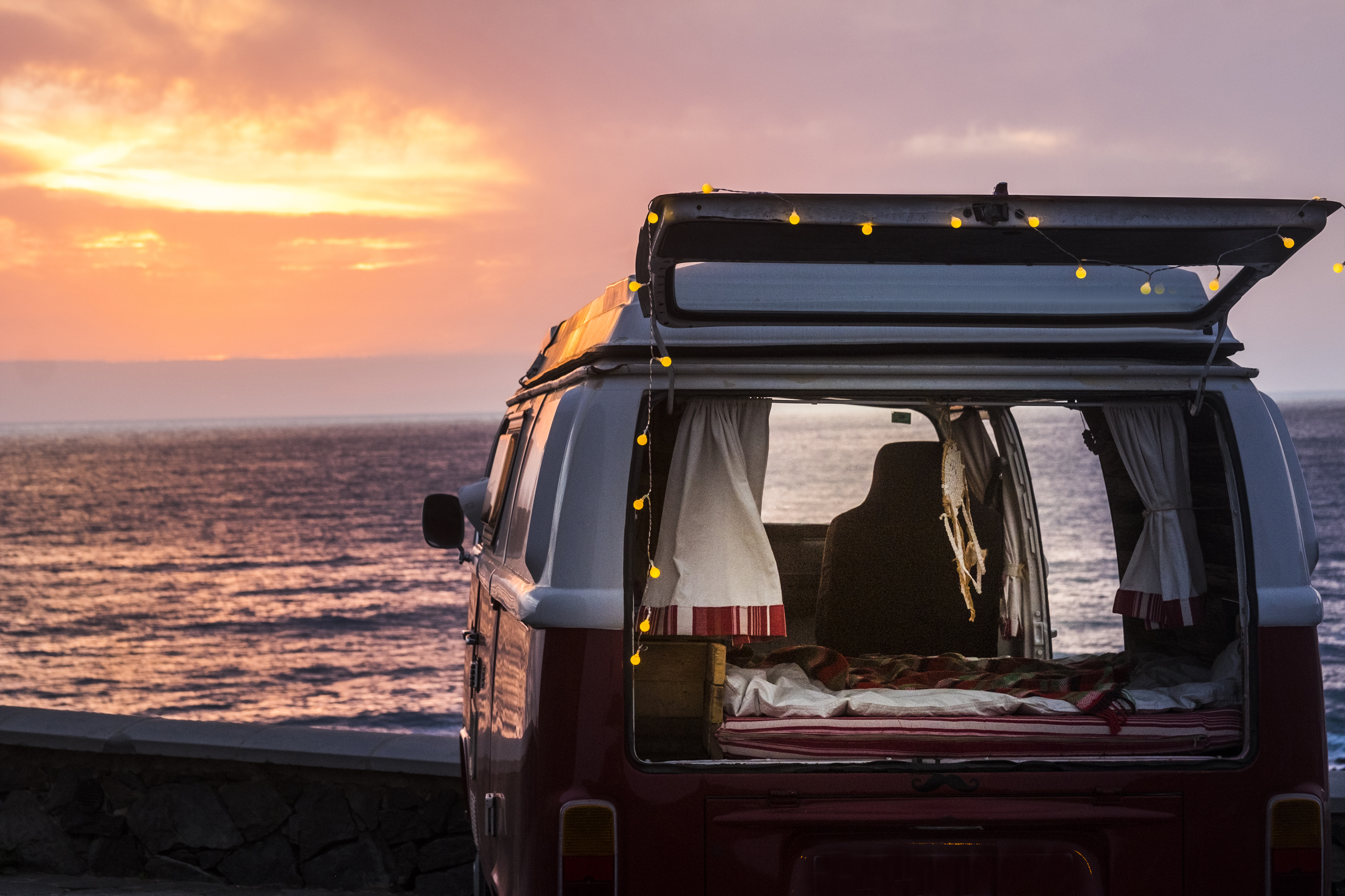 Vinage camper with a dream catcher at the sea at sunset