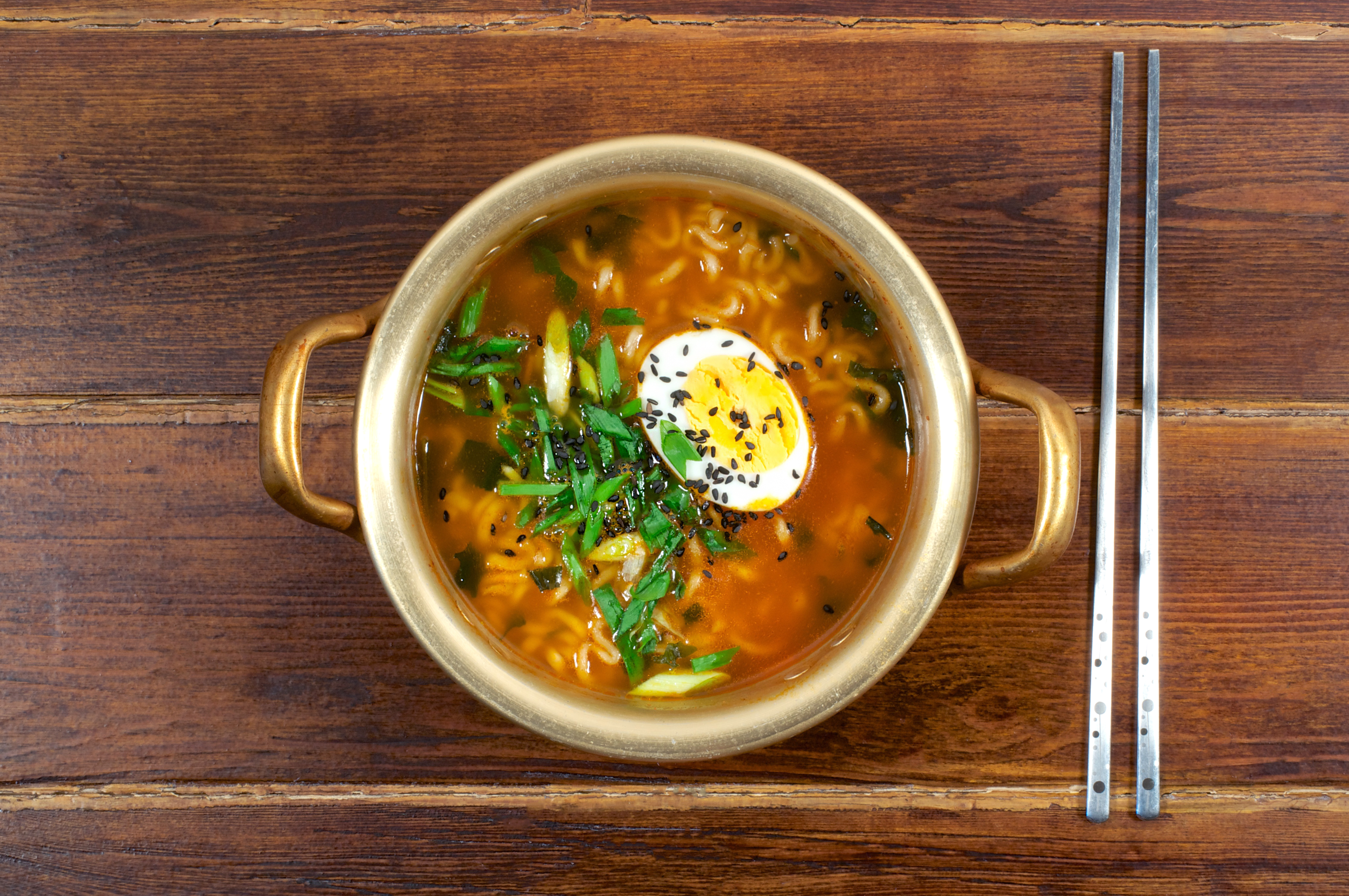 Korean ramen with egg and green onion on golden pan