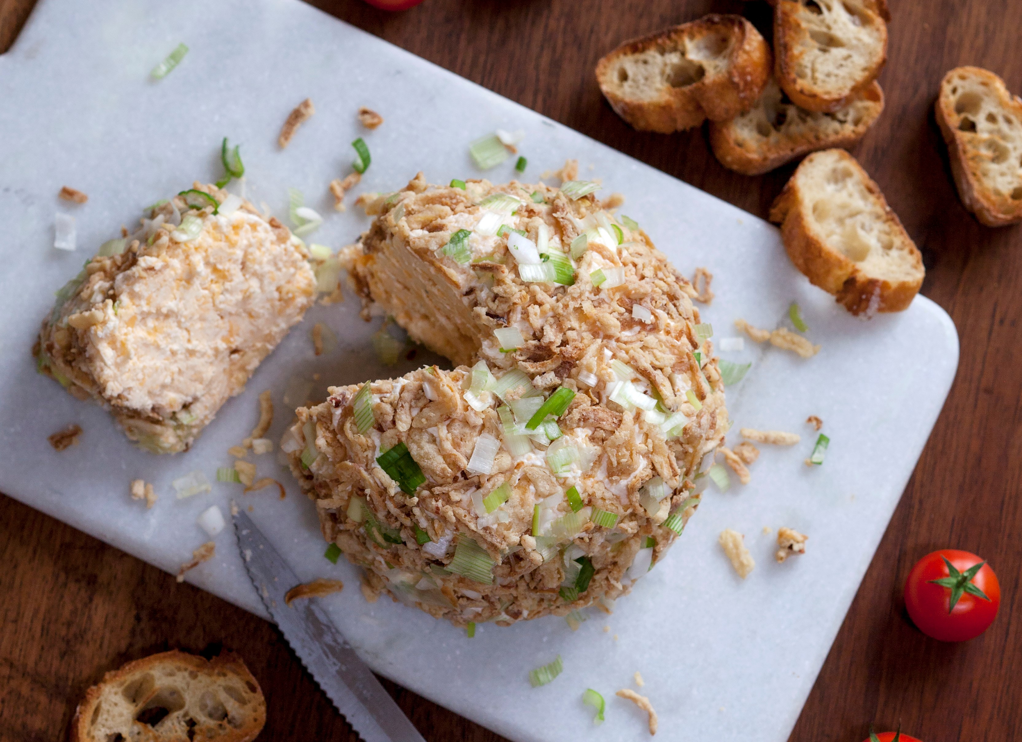 Käseball mit getrockneten Zwiebeln und Frühlingszwiebeln