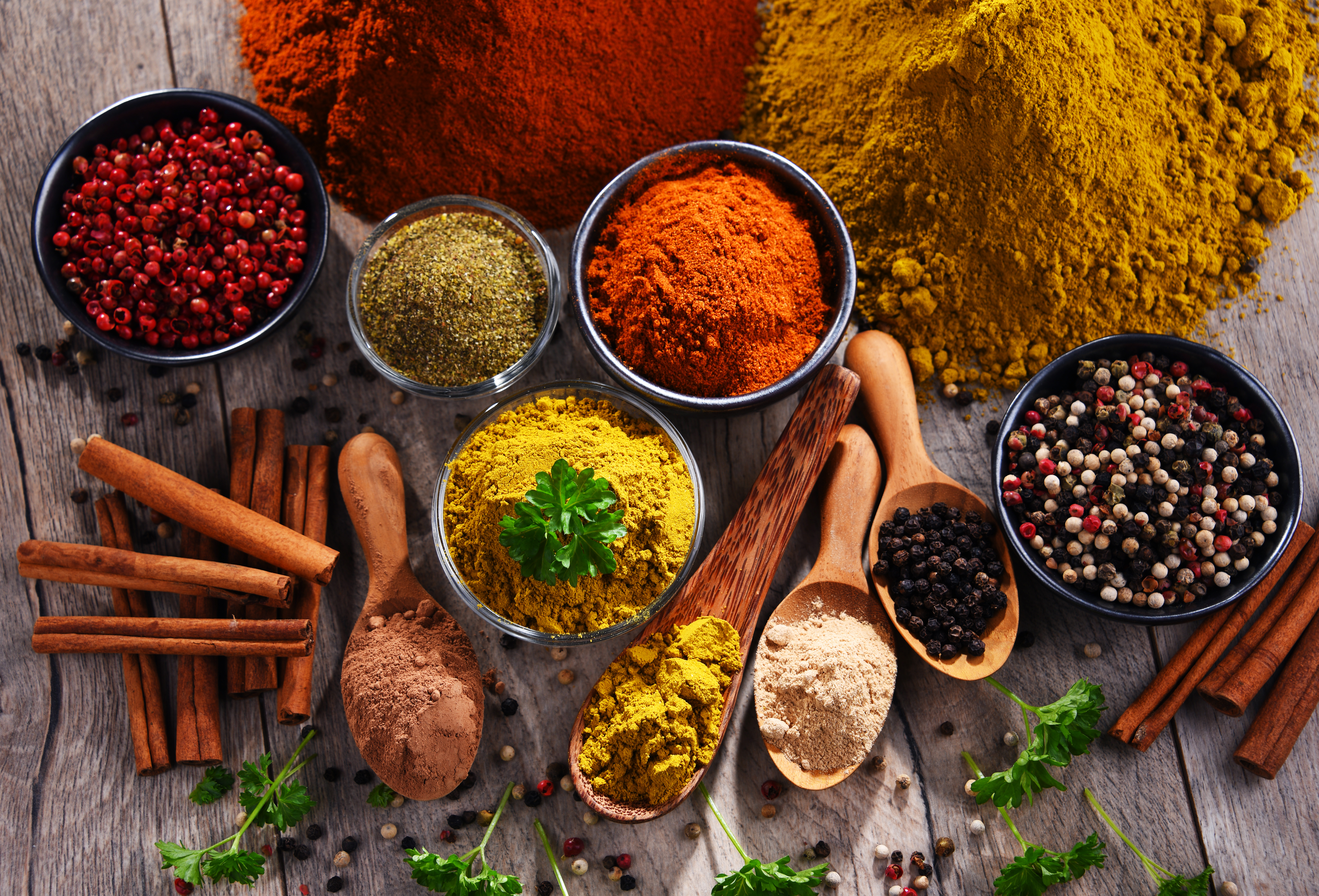 Variety of spices on wooden kitchen table.