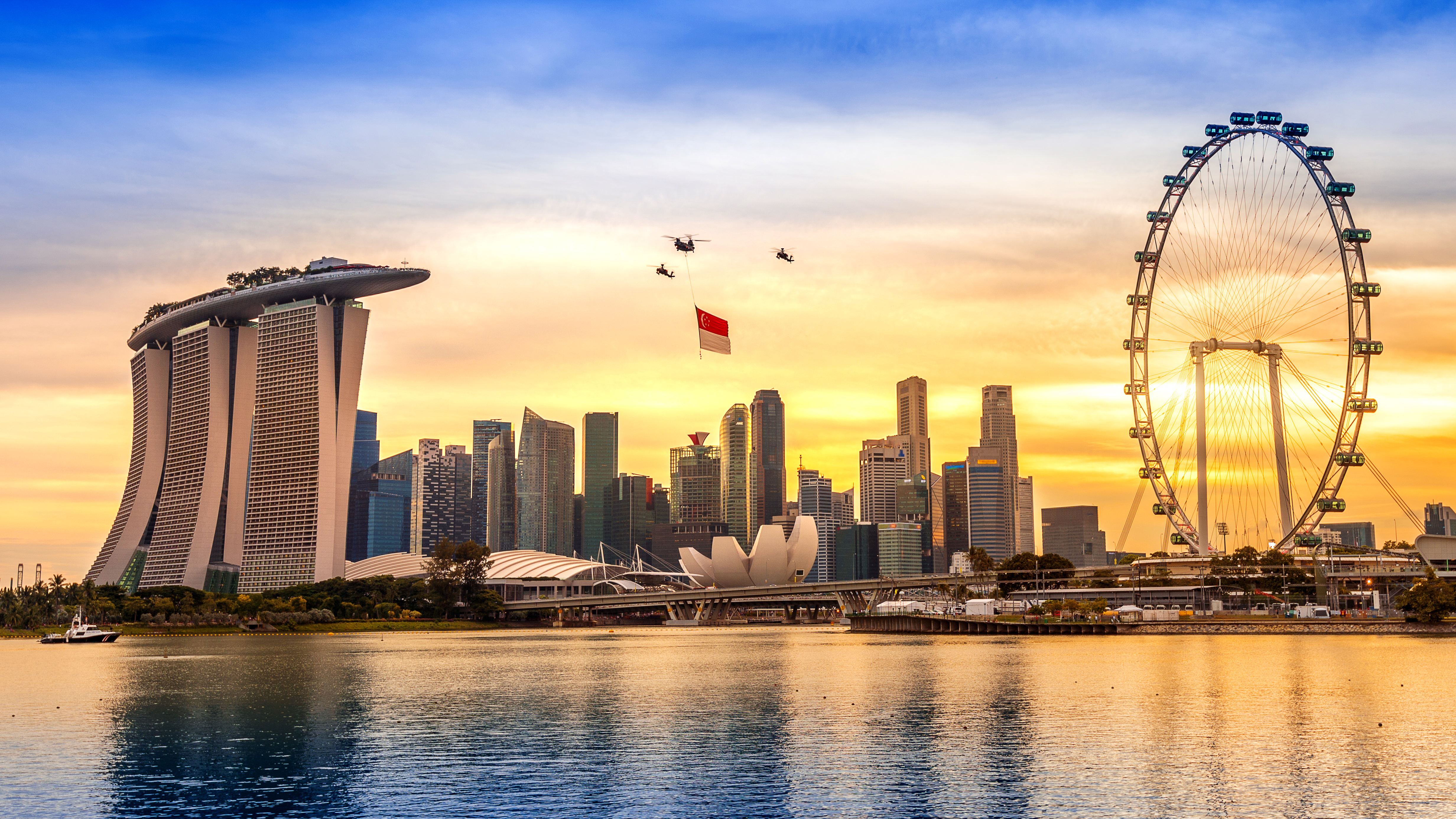 Singapore National Day helicopter hanging Singapore flag flying over the city.