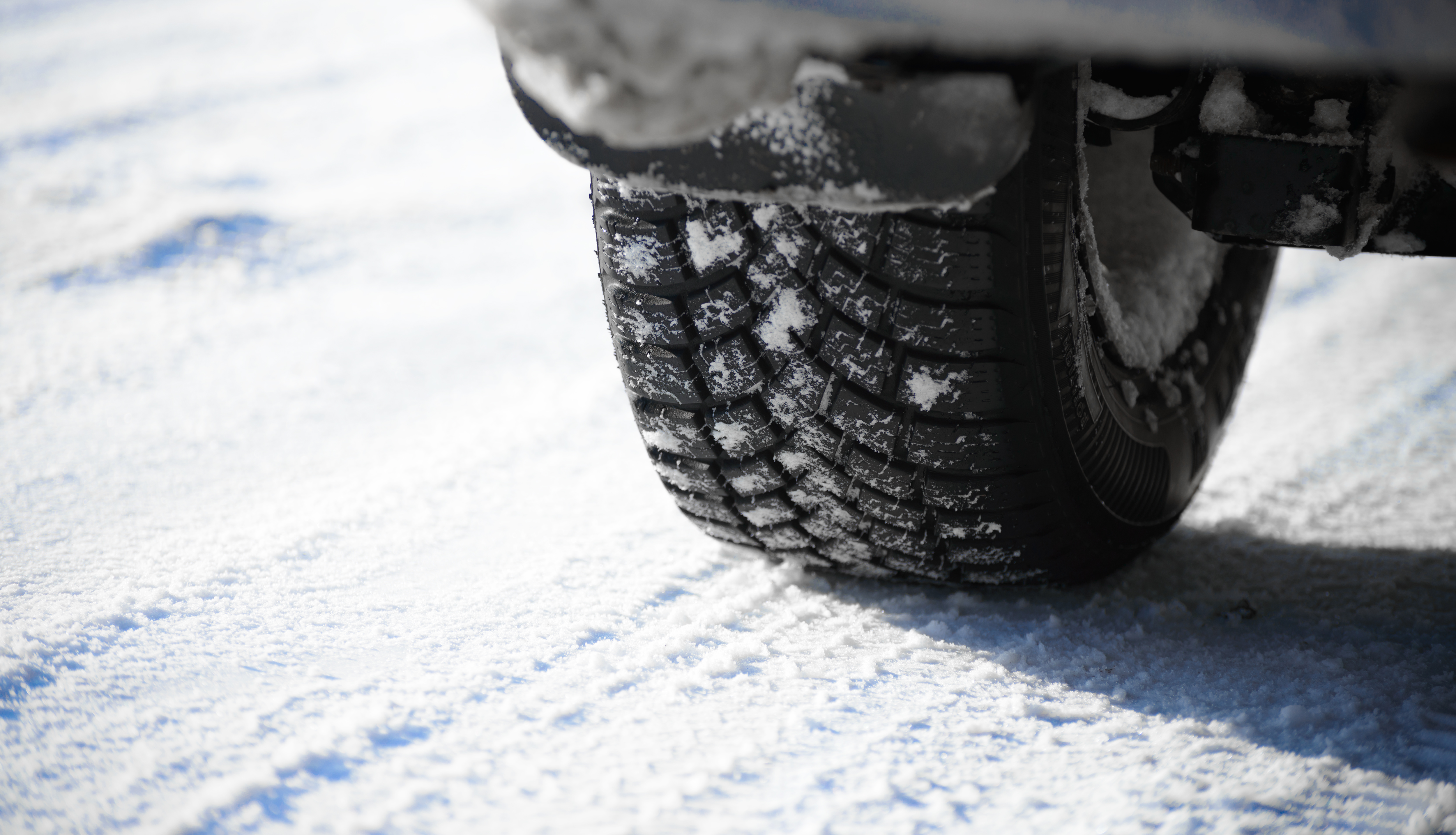 Close-up Image of Winter Car Tire on the Snowy Road. Drive Safe Concept