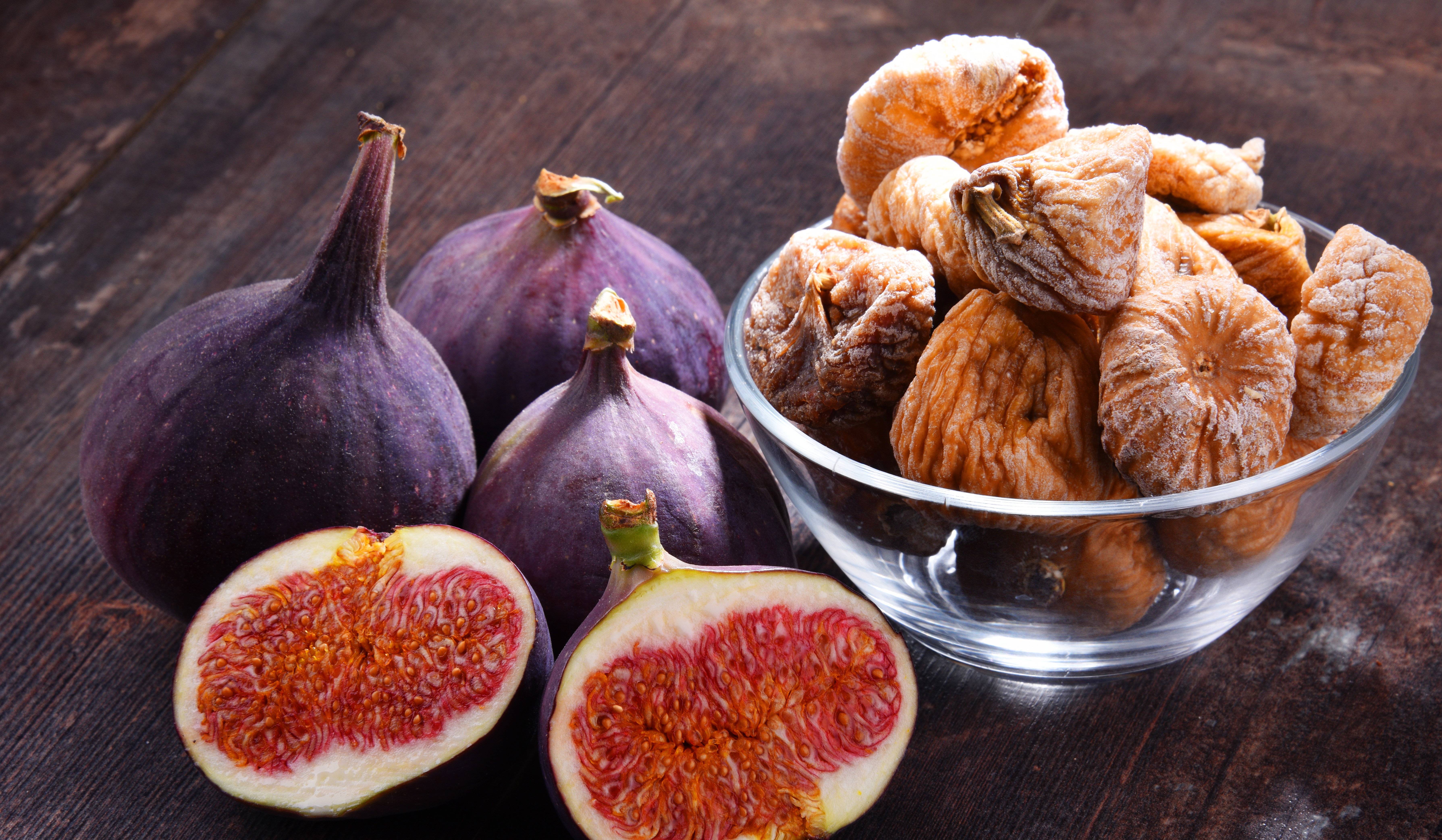 Composition with fresh and dried figs on wooden table.