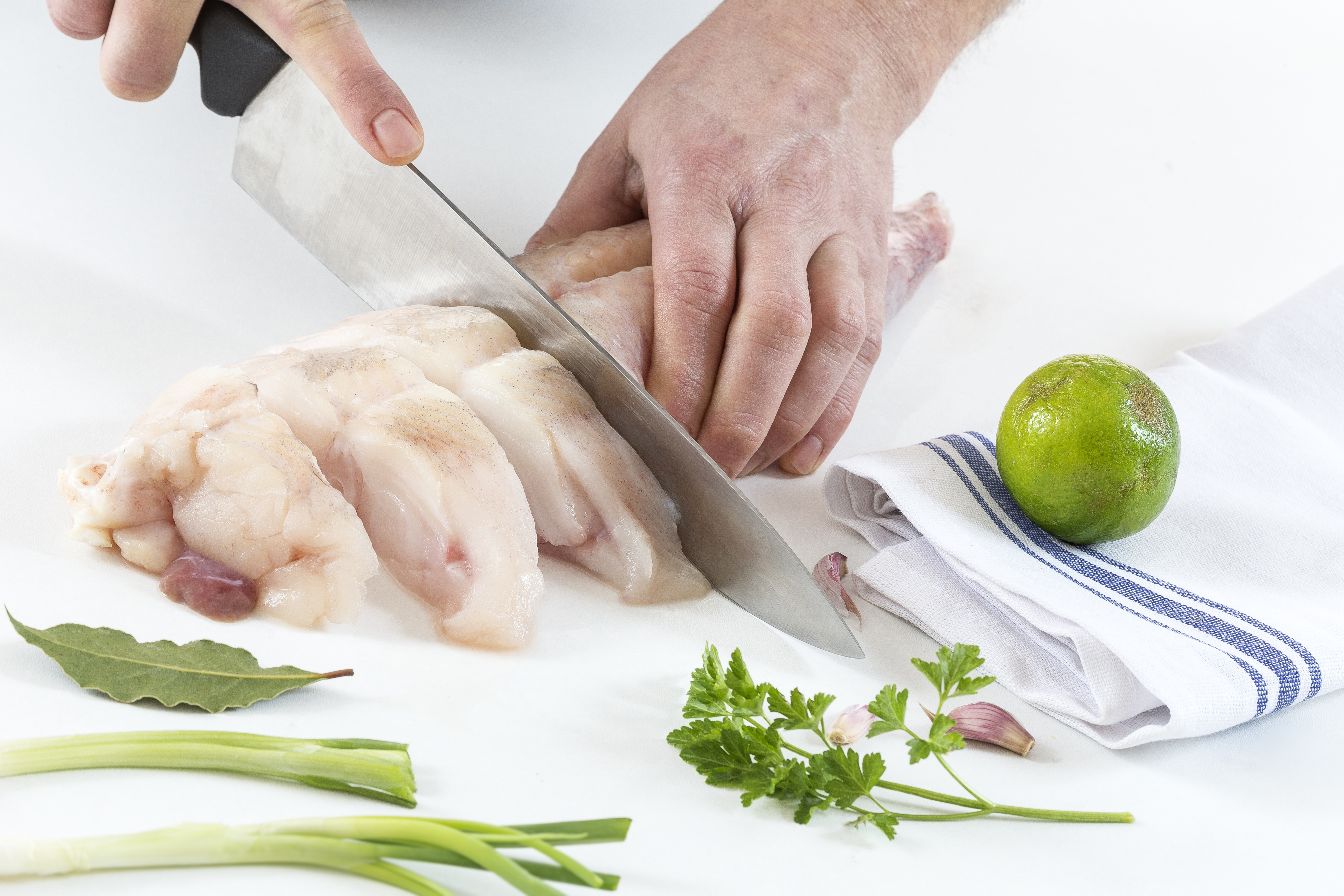 Person slicing the monkfish into steaks